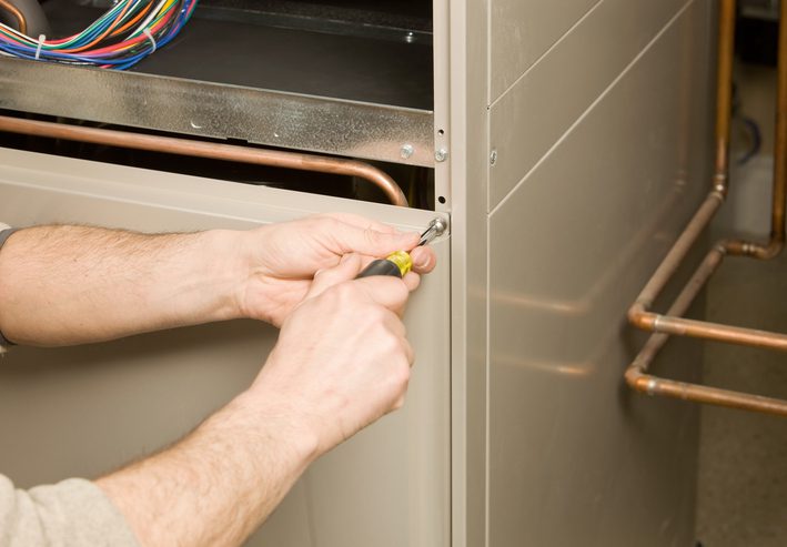 American Air Heating & Cooling | Rock Hill, SC | repair tech removing furnace service panel